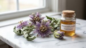 Flores secas de pasiflora junto a un frasco de tintura sobre mármol blanco